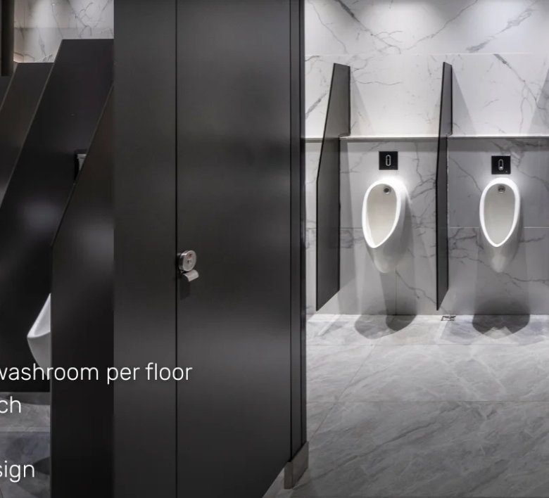 Modern men's washroom with four urinals and dark partitions along a marble wall; slide text promotes facilities.