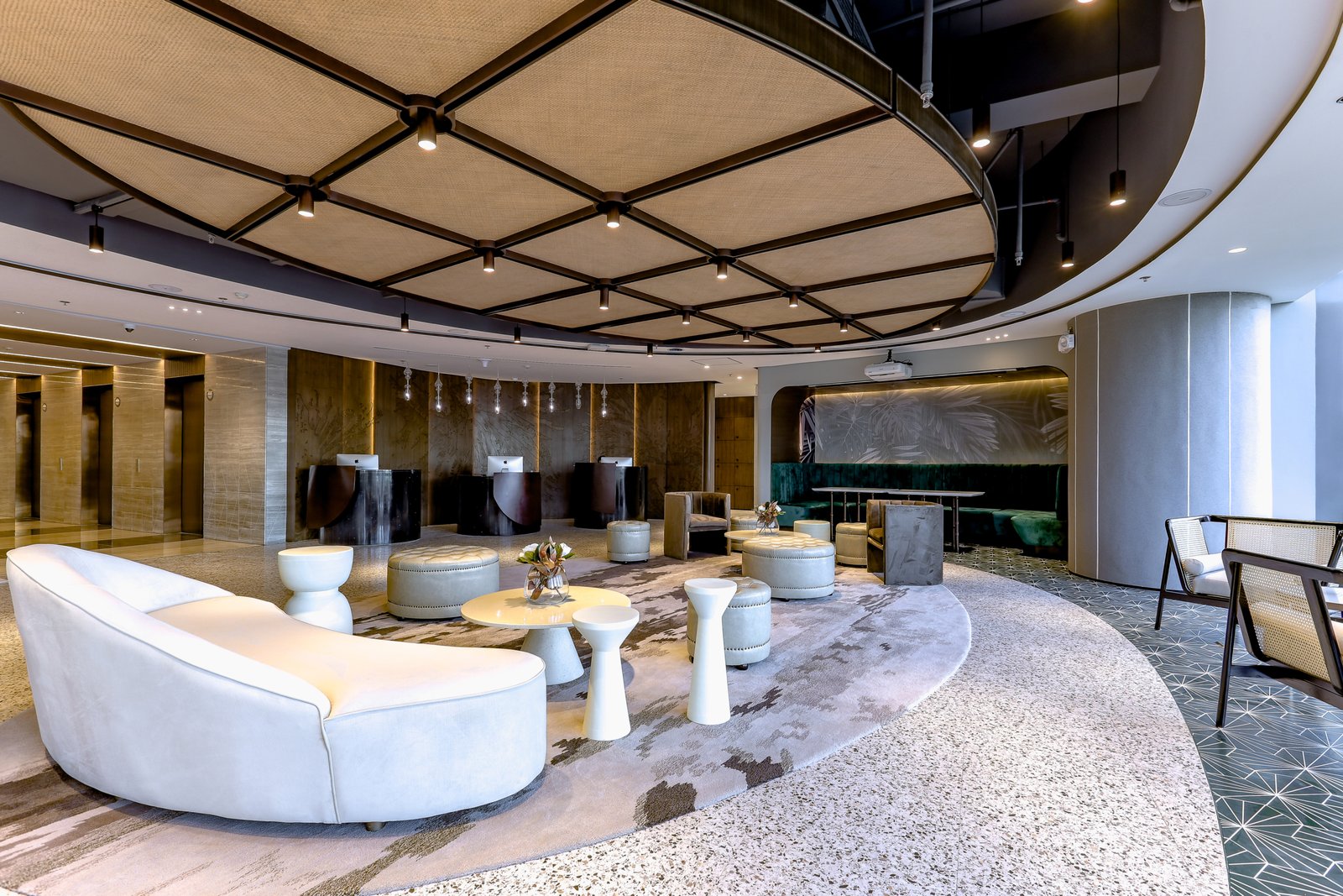 The Executive Centre Manila PH – Photoshoot 05.28.2021-15 Modern hotel lobby lounge with a domed, grid-pattern ceiling and pendant lights overseeing white curved sofas and round ottomans.