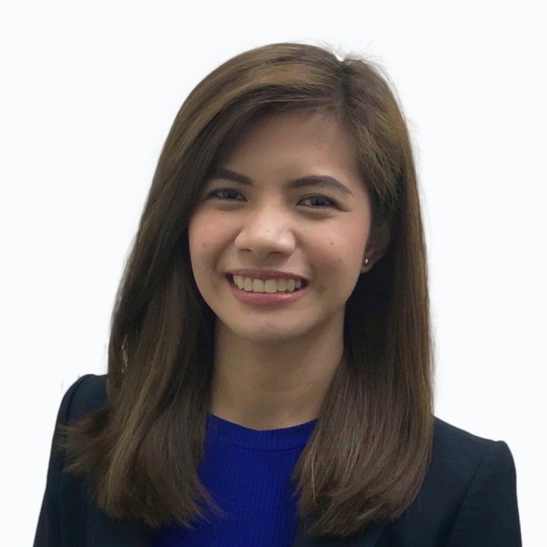 Smiling woman with shoulder-length brown hair, wearing a blue top and dark blazer, facing the camera.