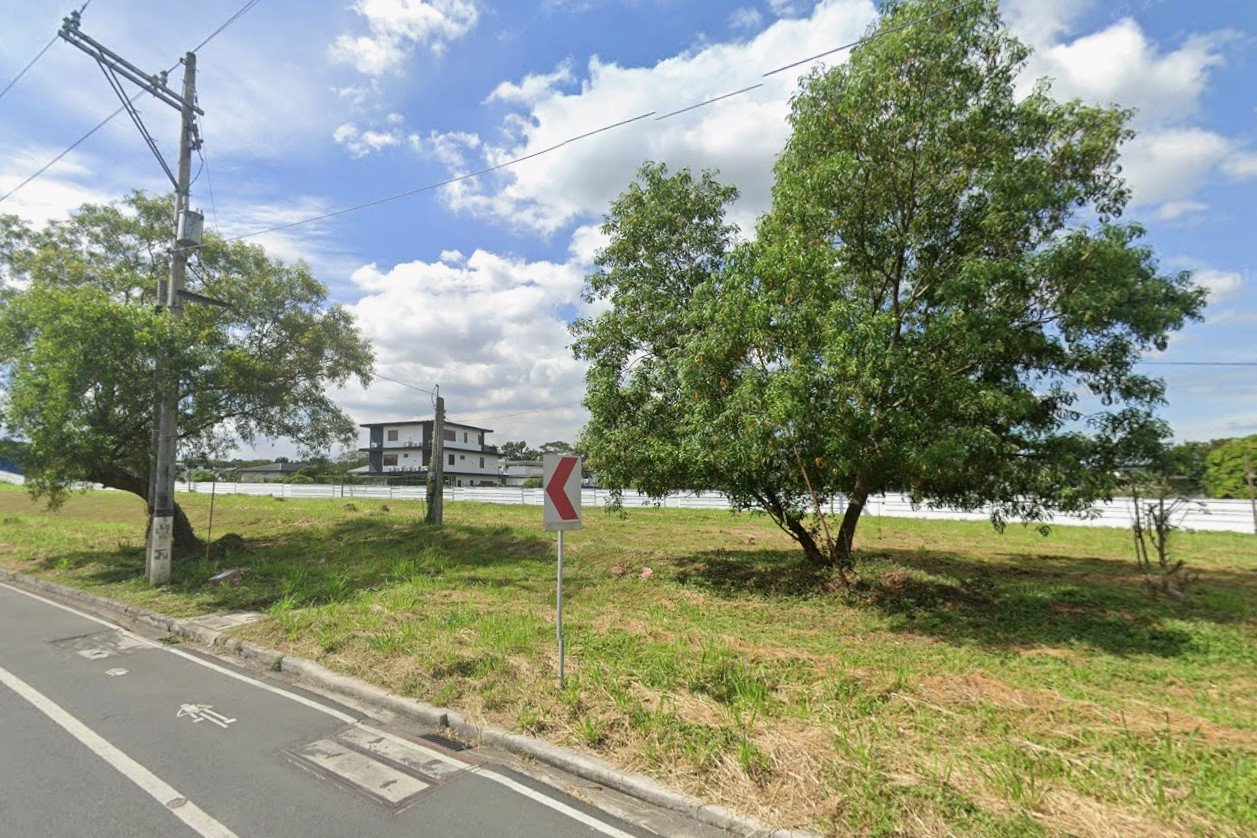 716 Roadside scene with a red chevron turn sign, a large tree, utility pole, and a grassy area under a blue sky with clouds.