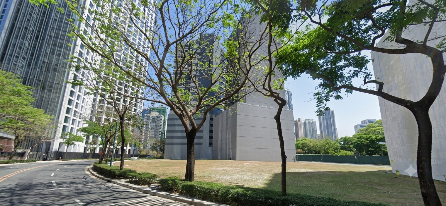 Urban street with a curved road, green trees arching overhead, and tall modern buildings on either side under a blue sky.