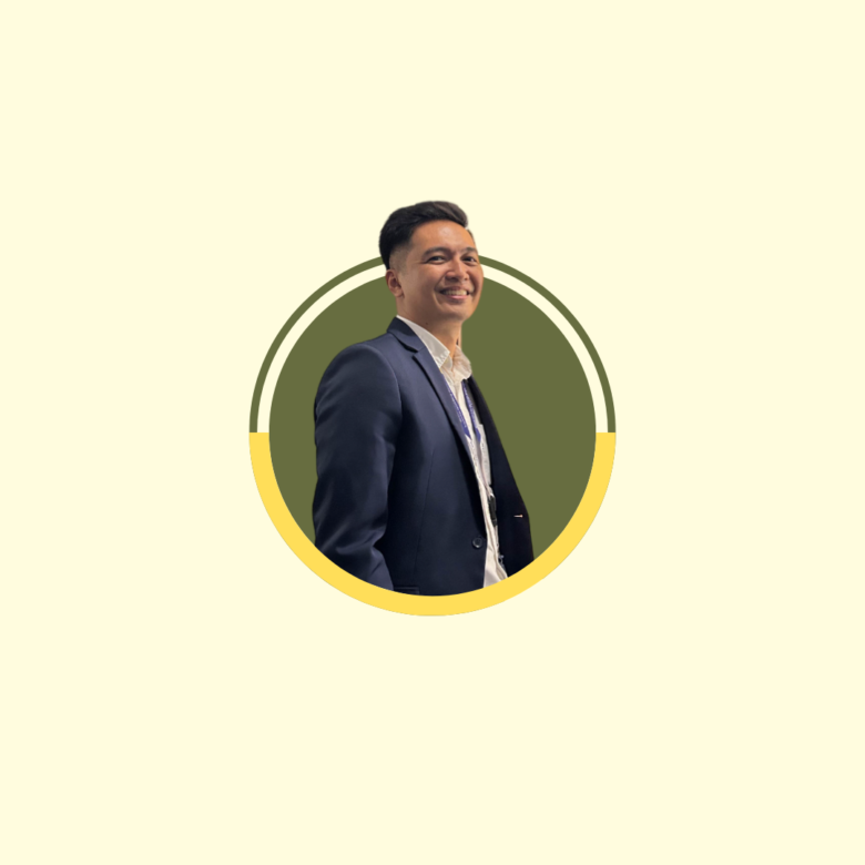 Professional portrait: smiling man in a navy suit, centered within a circular olive frame with yellow accents for a profile image.