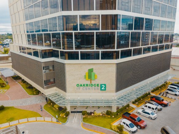 Aerial view of Oakridge IT Center building with a glass façade and green-yellow logo at the entrance.