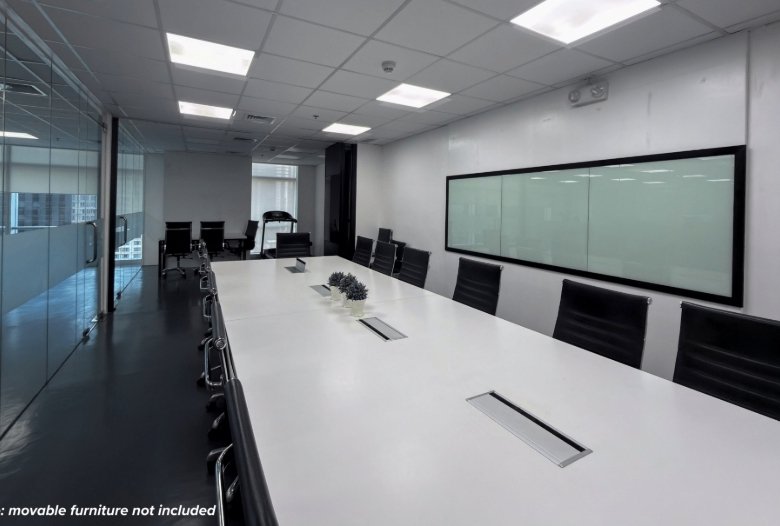 Empty modern conference room with a long white table, black chairs, glass wall on the left, and a large frosted glass board on the right