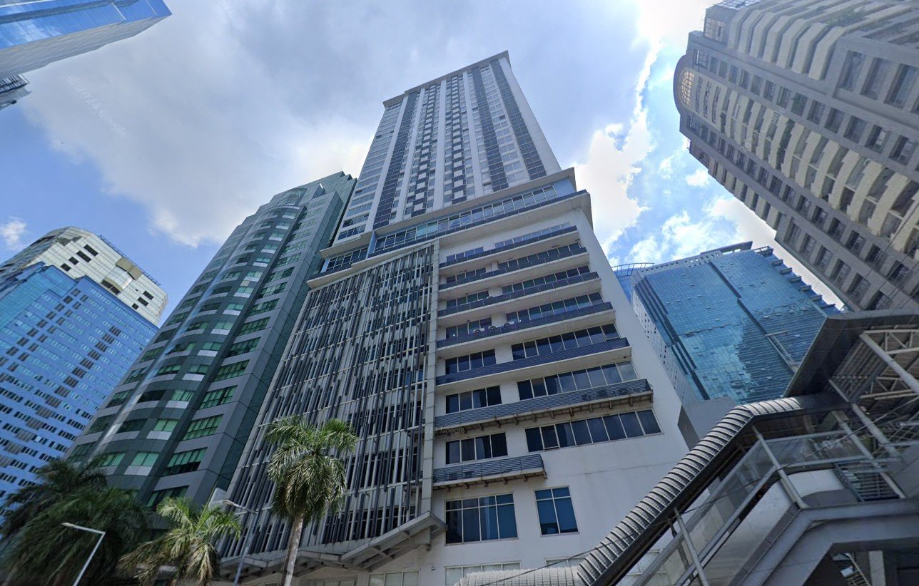 Low-angle view of modern high-rise buildings towering over palm trees in a city street area